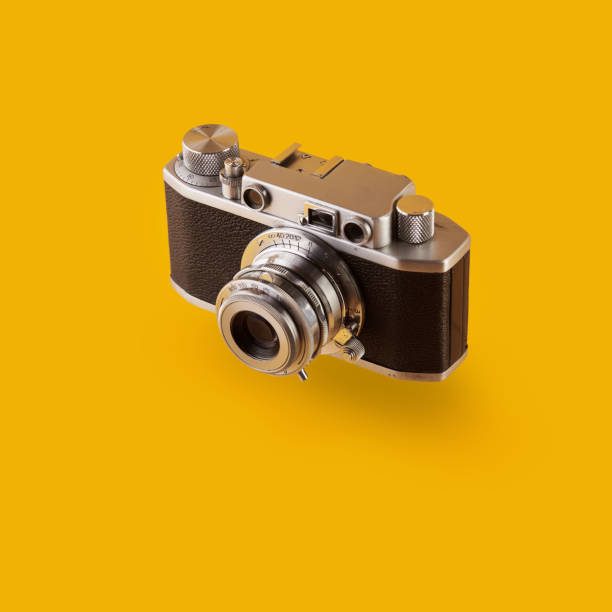 istock Vintage rangefinder film camera isolated on yellow / orange colored background 1209064580