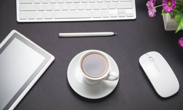 istock Coffee, computer keyboard, mouse, pen, tablet. Modern black business desk. Office 1209064817