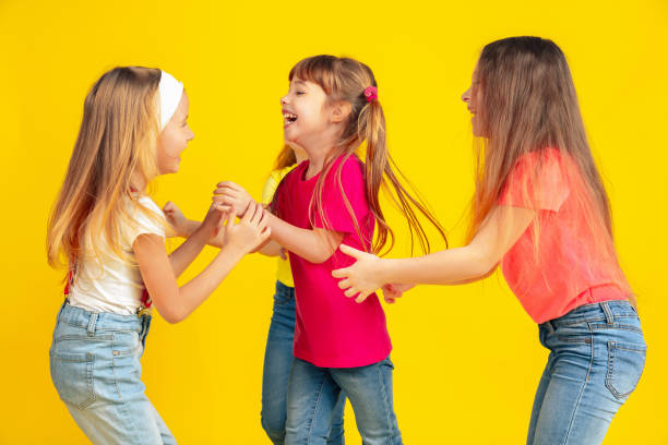 istock Happy children playing and having fun together on yellow studio background 1209064848