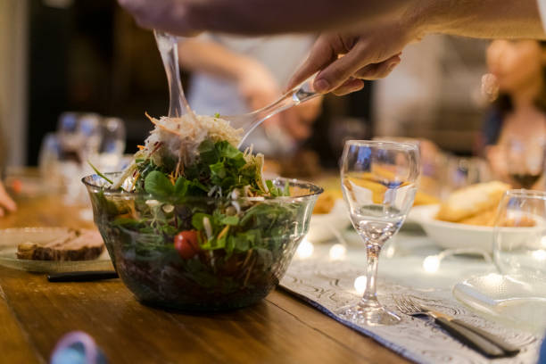 Close up dishing up salad with tongs