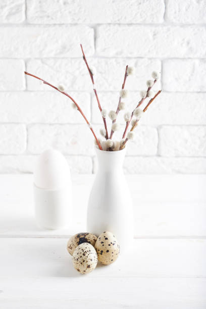 istock White vase with willow branch , white egg and cups on a white table Copy space Easter concept 1209075101