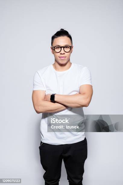 Confident Asian Young Man Standing With Arms Crossed Stock Photo - Download Image Now