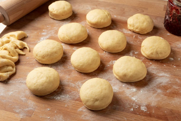 istock Raw filled  doughnuts made from yeast dough rising before being fried 1209075237