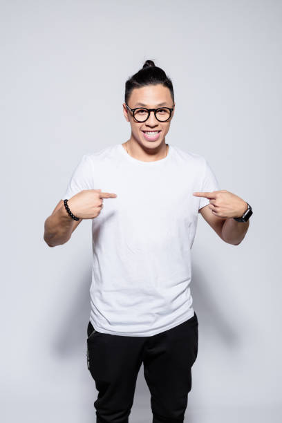 istock Friendly asian young man pointing at his t-shirt 1209075535