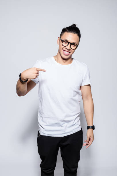 istock Friendly asian young man pointing at t-shirt 1209075619