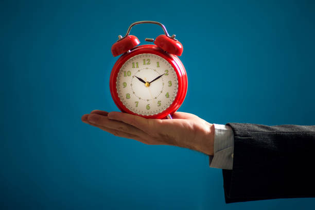 istock Bearded businessman holding alarm clock. Time management concept 1209076507