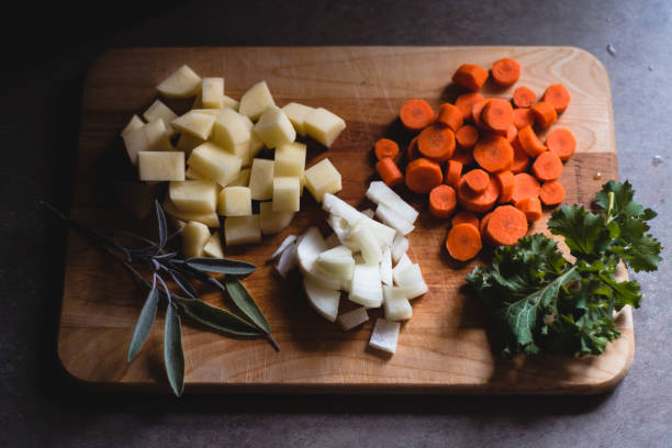 istock Potatoes, Carrots and Onion Cut up and Sitting on a Cutting Board 1209076744