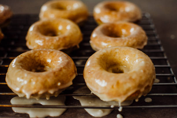 istock Iced Doughnuts Fresh out of the Oven Cooling on a Wire Rack 1209076748