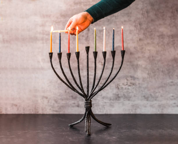 ハヌカのためのメノーラにろうそくを点灯する手のトリミングされた画像。 - hanukkah menorah human hand lighting equipment ストックフォトと画像