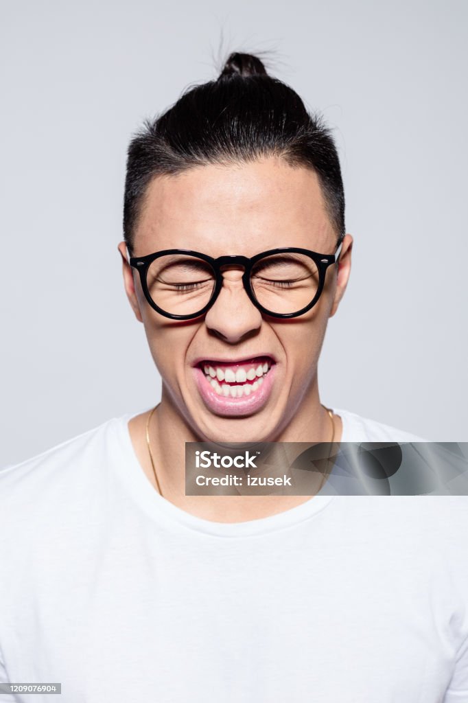 Headshot of happy asian young man Portrait of happy asian young man wearing white t-shirt and glasses, laughing with eyes closed. Studio shot on white background. 20-24 Years Stock Photo