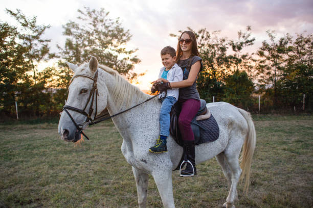 istock Cheerful siblings horseback riding on a ranch 1209078003