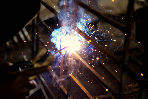 istock A welder at work in a workshop produces metal structures. Sparks from welding fly around. 1209078173