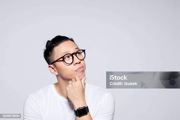 Portrait Of Pensive Asian Young Man Stock Photo - Download Image Now - Contemplation, Asking, Men