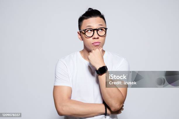 Portrait Of Pensive Asian Young Man Stock Photo - Download Image Now - Men, Contemplation, Portrait