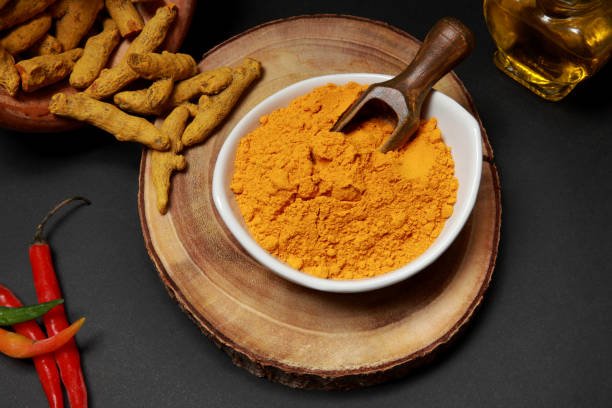 radici di curcuma indiana e da terra a polvere - spice ayurveda herb curry powder foto e immagini stock