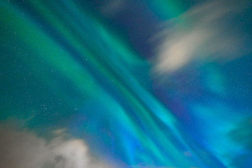 Close up of green aurora northern lights and stars in Lofoten islands, Norway. Sky with polar lights at night in winter season. Nature landscape background.