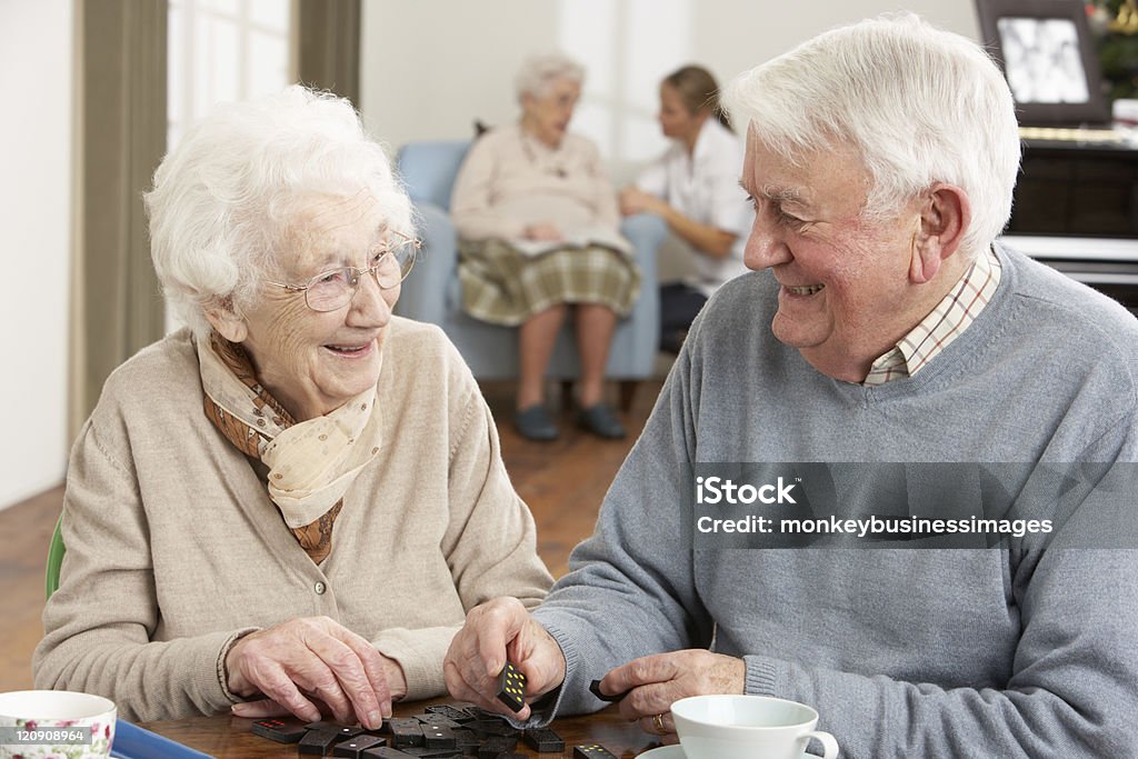 Couple jouant aux dominos à jour Centre de soins - Photo de Centre gériatrique libre de droits