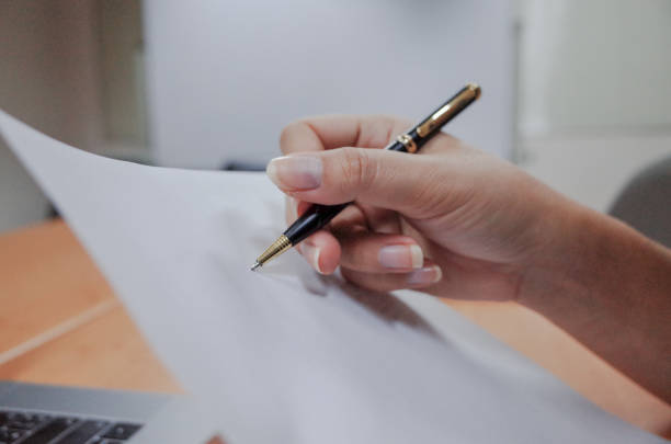 istock Business women signing a document after reading the agreement 1209091225