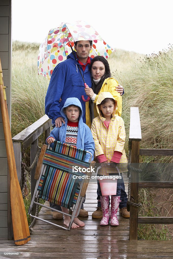 Семья на пляже с зонтик - Стоковые фото Дождь роялти-фри