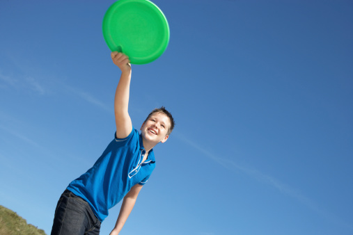 Young boy playing with frisbee on beach