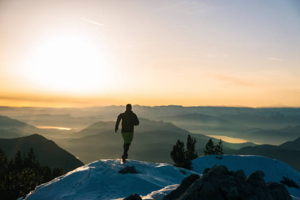 istock Trail runner ascends snowy mountain ridge crest at dawn 1209092246