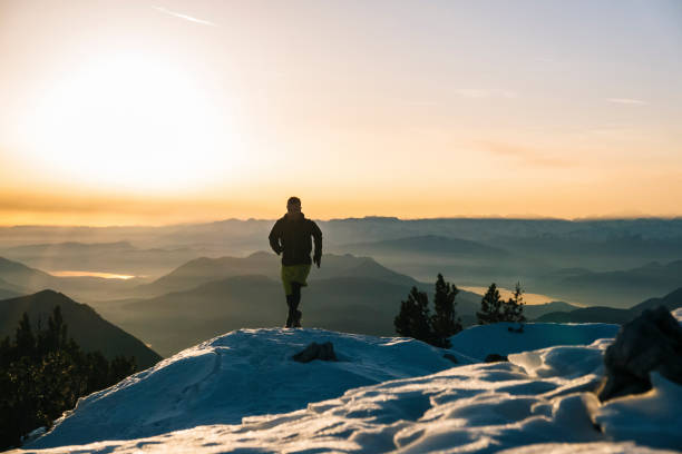 istock Trail runner ascends snowy mountain ridge crest at dawn 1209092293