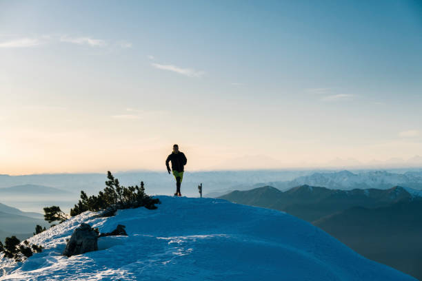 istock Trail runner ascends snowy mountain ridge crest at dawn 1209092601