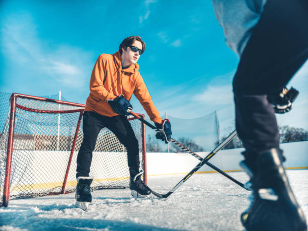 vater und sohn spielen hockey im freien - ice skating ice hockey child family stock-fotos und bilder