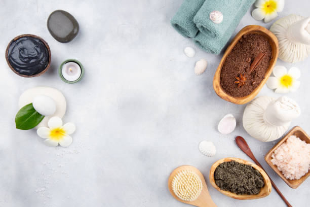 istock Beautiful spa relax concept. Coffee with cinnamon scrub, green tea scrub, cotton pouches with herbs for massage, sea stones and other Spa accessories on table. Copy space. 1209097257