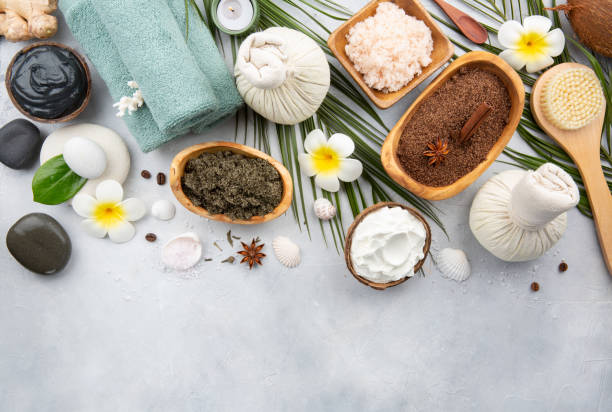 istock Beautiful spa relax concept. Coffee with cinnamon scrub, green tea scrub, cotton pouches with herbs for massage, sea stones and other Spa accessories on table. Copy space. 1209097449