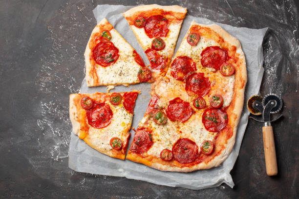istock Home made pizza with chorizo, mozzarella and tomatoes on table top view 1209100160