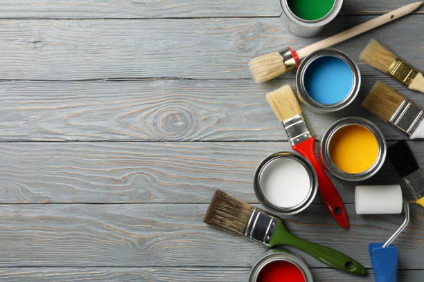 istock Different paints, brushes and roller on wooden background, top view 1209105562