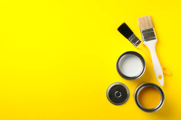 istock Cans of paints and brushes on yellow background, top view 1209105577