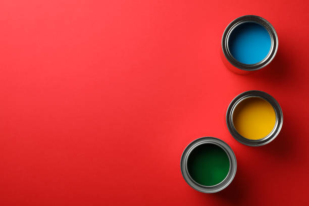 istock Cans of different paints on red background, top view 1209105684