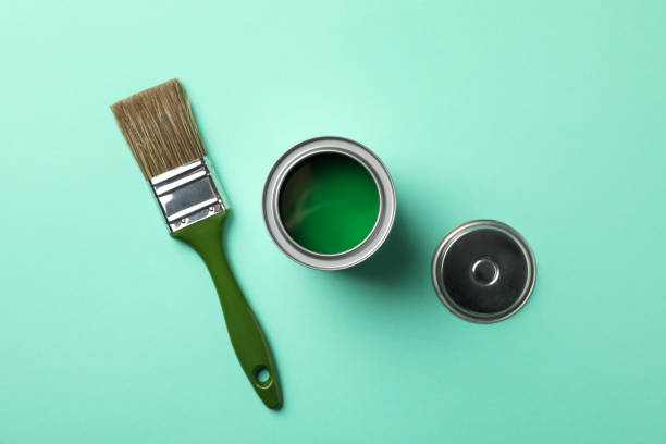istock Paint can and brush on green background, top view 1209105702