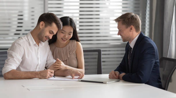 istock Happy mixed race married spouse signing contract with bank manager. 1209105736