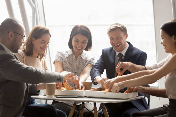 istock Happy mixed race company workers sharing lunch, eating pizza. 1209105759