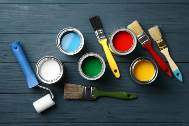istock Different paints, brushes and roller on wooden background, top view 1209105793