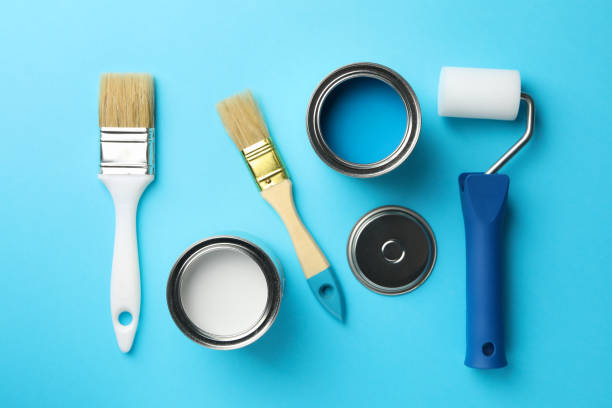 istock Paint cans, brushes and roller on blue background, top view 1209105831