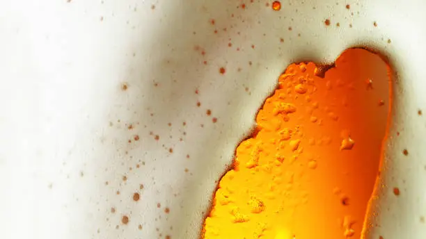 Detail of beer drink with overflowing foam head, super macro shot