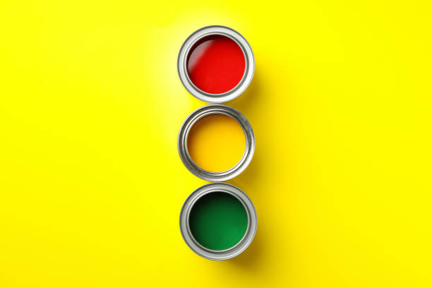 istock Cans of different paints on yellow background, top view 1209107616