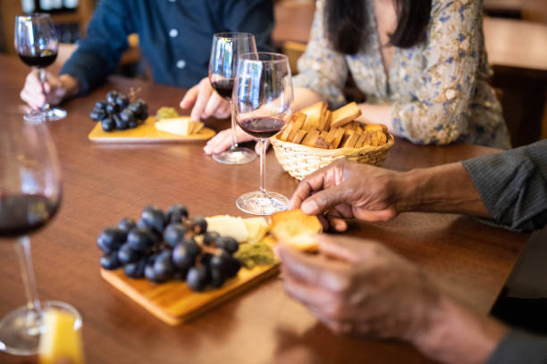 food and drinks served on table with people at wine bar - wine cellar wine bottle grape imagens e fotografias de stock