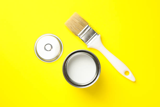 istock Paint can and brush on yellow background, top view 1209108263