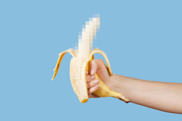 hidden censored banana in hand on a blue background. horny (aroused) penis, male erection and sexual education. funny pornography - orgasm imagens e fotografias de stock