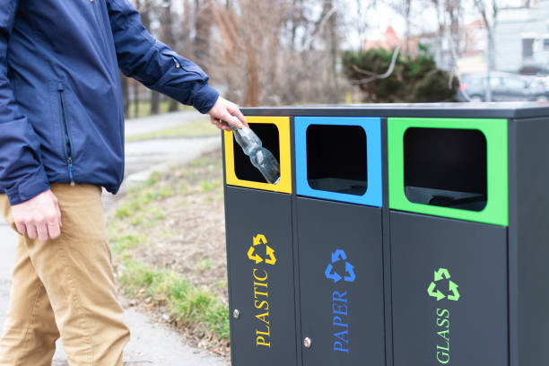 istock Hand of man throwing plactic bottle into trash bin for plastic waste. Modern colorful refuse bins for separate trash. 1209109668