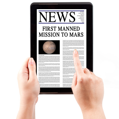 Digital news about first manned mission to Mars on a tablet computer.