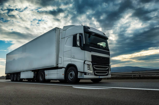 istock White semi trailer lorry truck on a highway at sunset 1209114465
