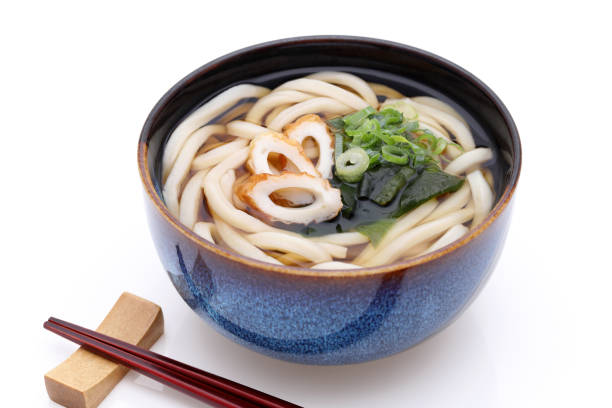 Japanese Kake udon noodles in bowl with chopsticks Japanese Kake udon noodles in a ceramic bowl with chopsticks on white background chikuwa stock pictures, royalty-free photos & images
