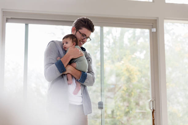 istock Confident new dad walks his baby at home 1209118002