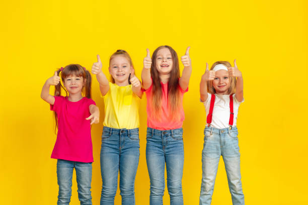 istock Happy children playing and having fun together on yellow studio background 1209118048